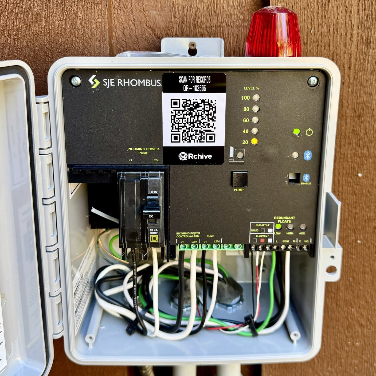 A QRchive sticker on a septic system control panel, where the next technician scans for the full record
